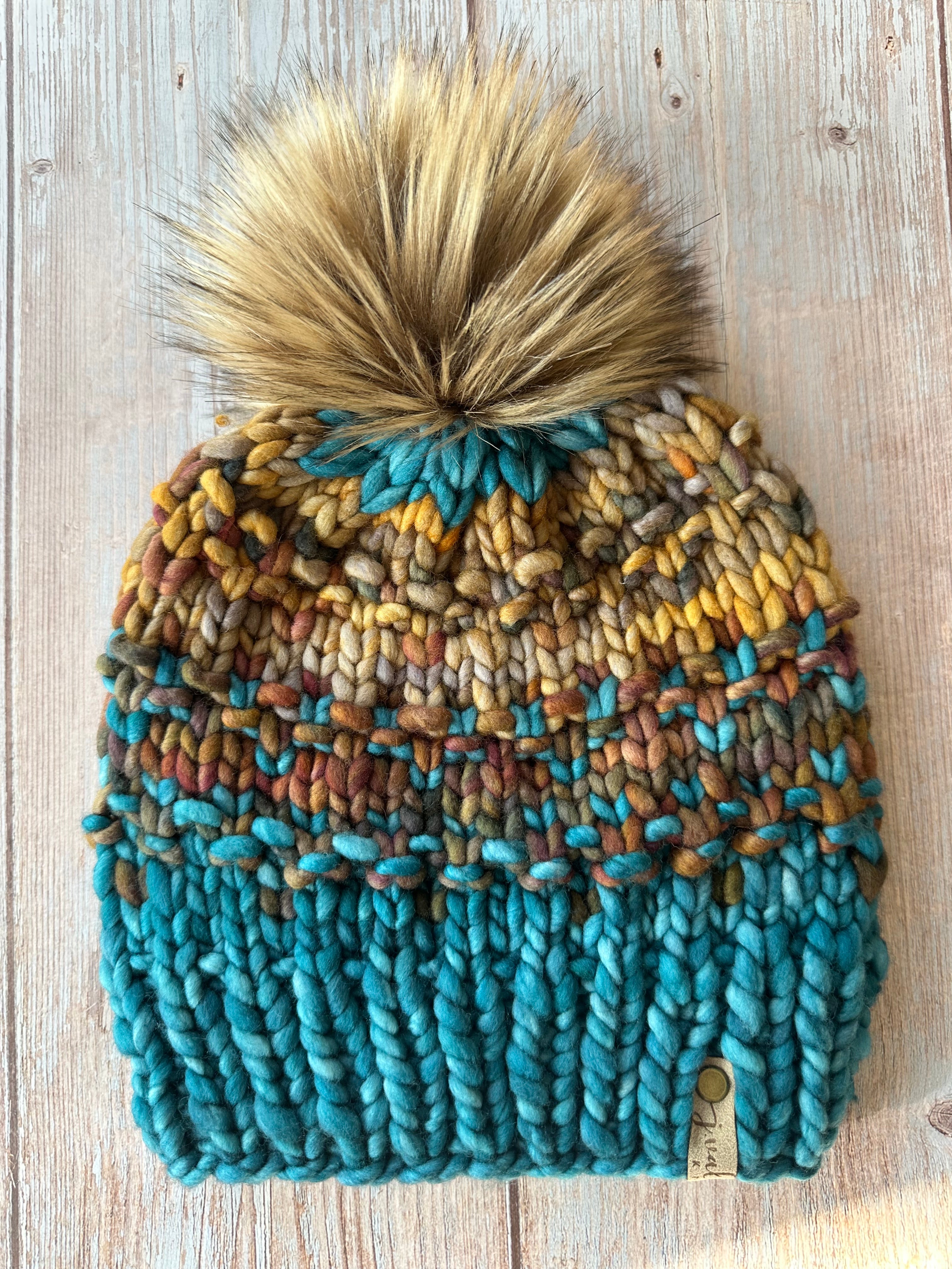 Luxury hand knit beanie with removable store pom pom and tag